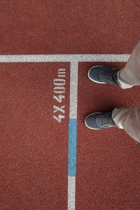 Directly above of man standing on track field