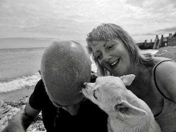 Mature couple with dog at shore of beach