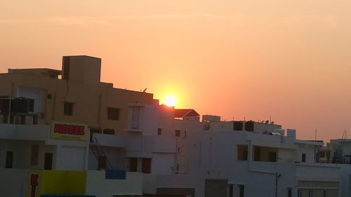 Houses against sky during sunset