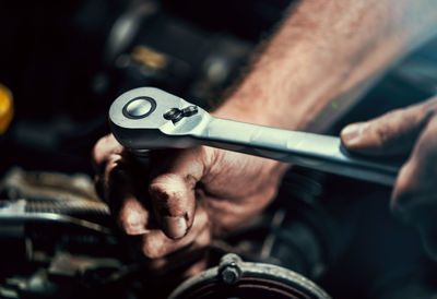 Close-up of man repairing engine