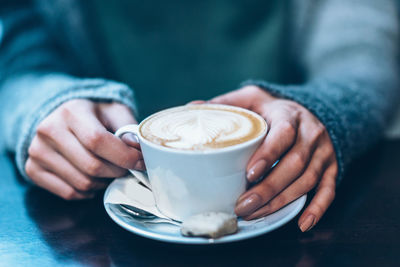 Cropped image of hand holding coffee cup