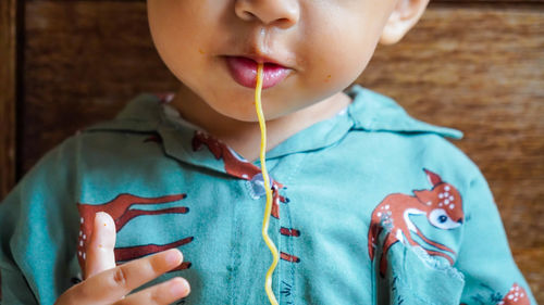 Close-up baby eating noodles