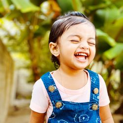 Close-up of smiling girl standing outdoors