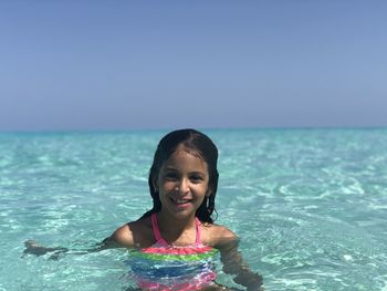 Portrait of girl in crystal clear water sea and clear blue skies
