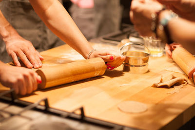 Cropped hands preparing food on table in kitchen