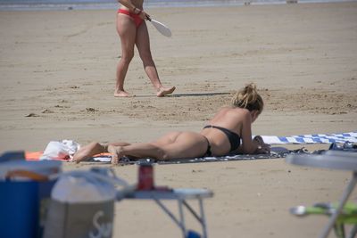 Woman playing with sand on beach