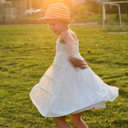 Side view of girl wearing hat on field