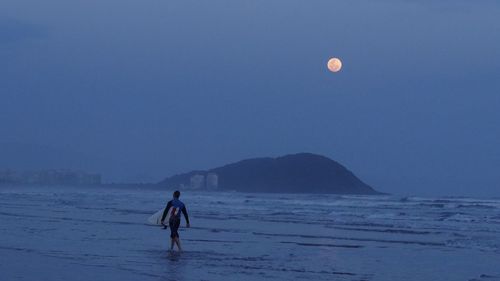 Full length of man at beach against clear sky and moon