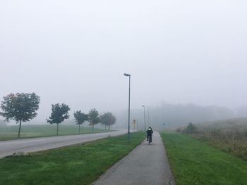 Man walking on road against sky