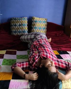 High angle view of woman relaxing on bed at home
