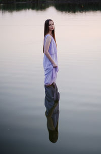 Full length of woman standing on lake