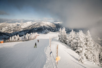 Skiers on empty slopes during covid-19 pandemic in the austrian alps.