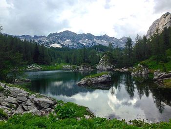 Scenic view of lake by mountains against sky