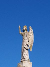 Low angle view of statue against blue sky