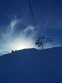 Low angle view of ski lift against blue sky