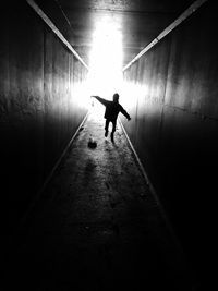 Silhouette man in illuminated corridor
