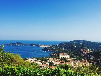 Scenic view of residential district and sea against clear sky