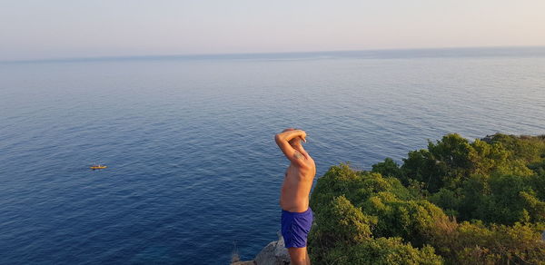 Rear view of man looking at sea against sky