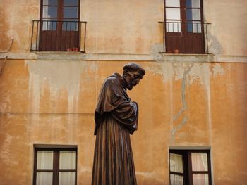 Side view of man standing against building