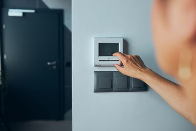 Woman controlling office with digital touch screen panel installed on the wall in office. smart home