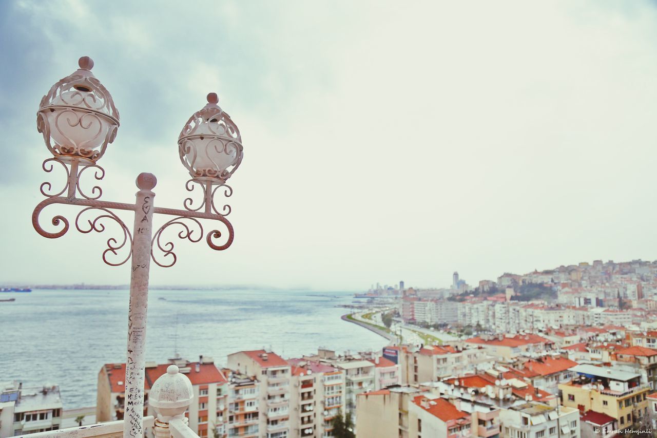 sea, building exterior, architecture, built structure, water, sky, city, horizon over water, nautical vessel, outdoors, day, transportation, street light, cloud - sky, residential building, cityscape, residential structure, no people, lighting equipment, mode of transport