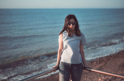 Full length of young woman standing on beach