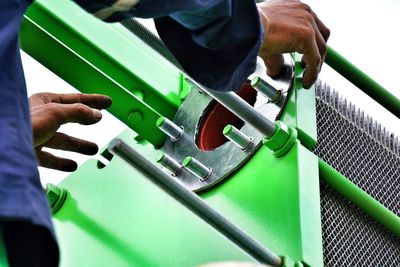 Close-up of person repairing machine at factory