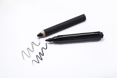 High angle view of pen on paper against white background