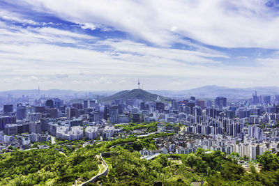 Buildings in city against cloudy sky