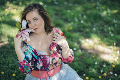 Portrait of young woman with eyes closed standing against plants