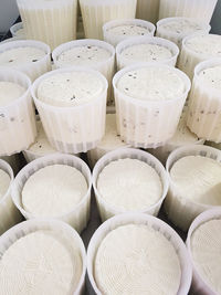 Fresh cheese in plastic molds on cheese factory in italy