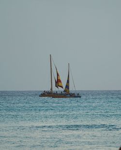 Sailboat sailing on sea against clear sky