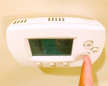 Close-up of person holding camera against wall