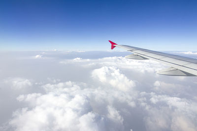 Airplane flying over cloudscape against sky