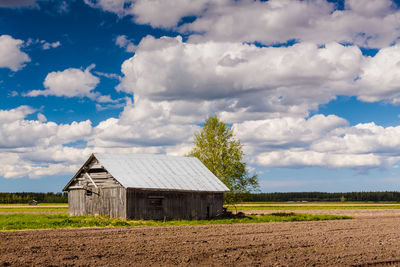 Scenic view of field against cloudy sky