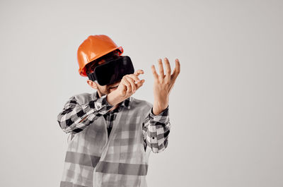 Midsection of man wearing hat standing against white background