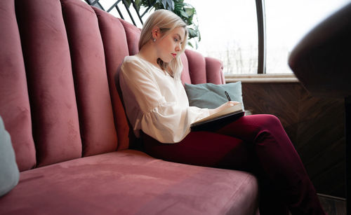 Woman sitting on sofa at home