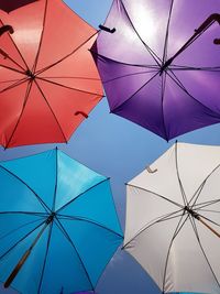 Directly below shot of umbrellas hanging against sky during summer