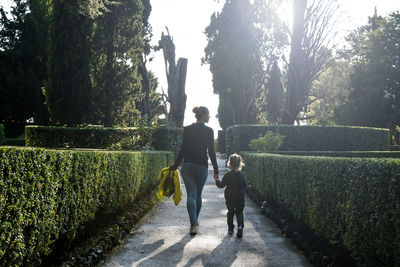 Rear view of people walking on footpath