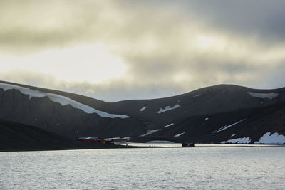 Scenic view of sea and mountains against sky