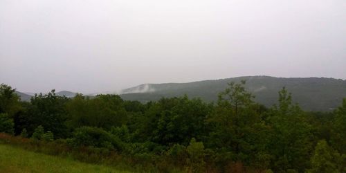 Scenic view of trees and mountains against sky