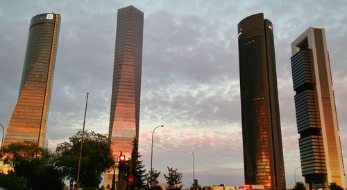 Low angle view of modern building against cloudy sky