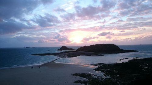 Scenic view of sea against dramatic sky during sunset