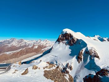 Scenic view of snowcapped mountains against clear blue sky