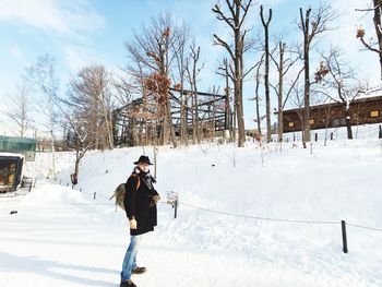 Portrait of man standing on snow covered land against sky