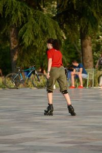 Rear view of woman rollerblading on road