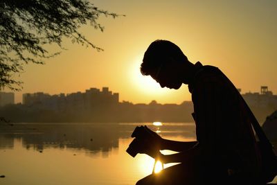 Silhouette of man working at sunset