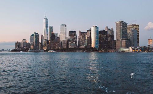 Sea and buildings against sky in city