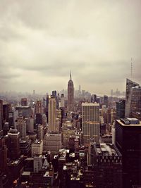 Modern buildings in city against cloudy sky