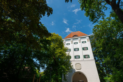 Low angle view of trees and building against sky